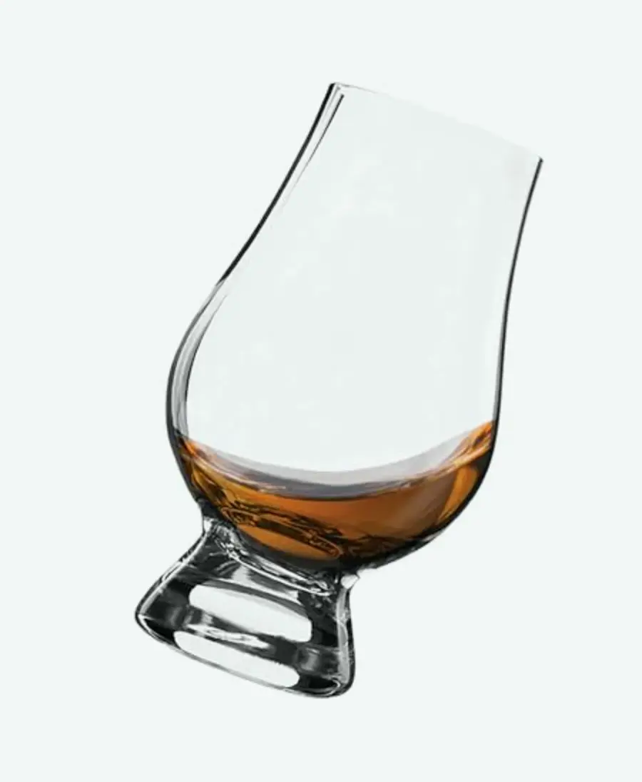 Glencairn whisky glass tilted with whisky inside.